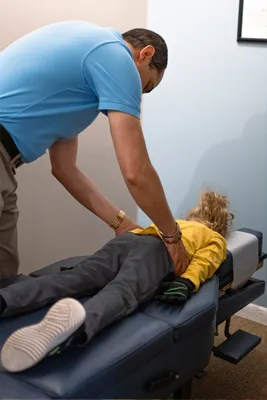 Chiropractor Virginia Beach VA Michael Vanella Adjusting Child Back